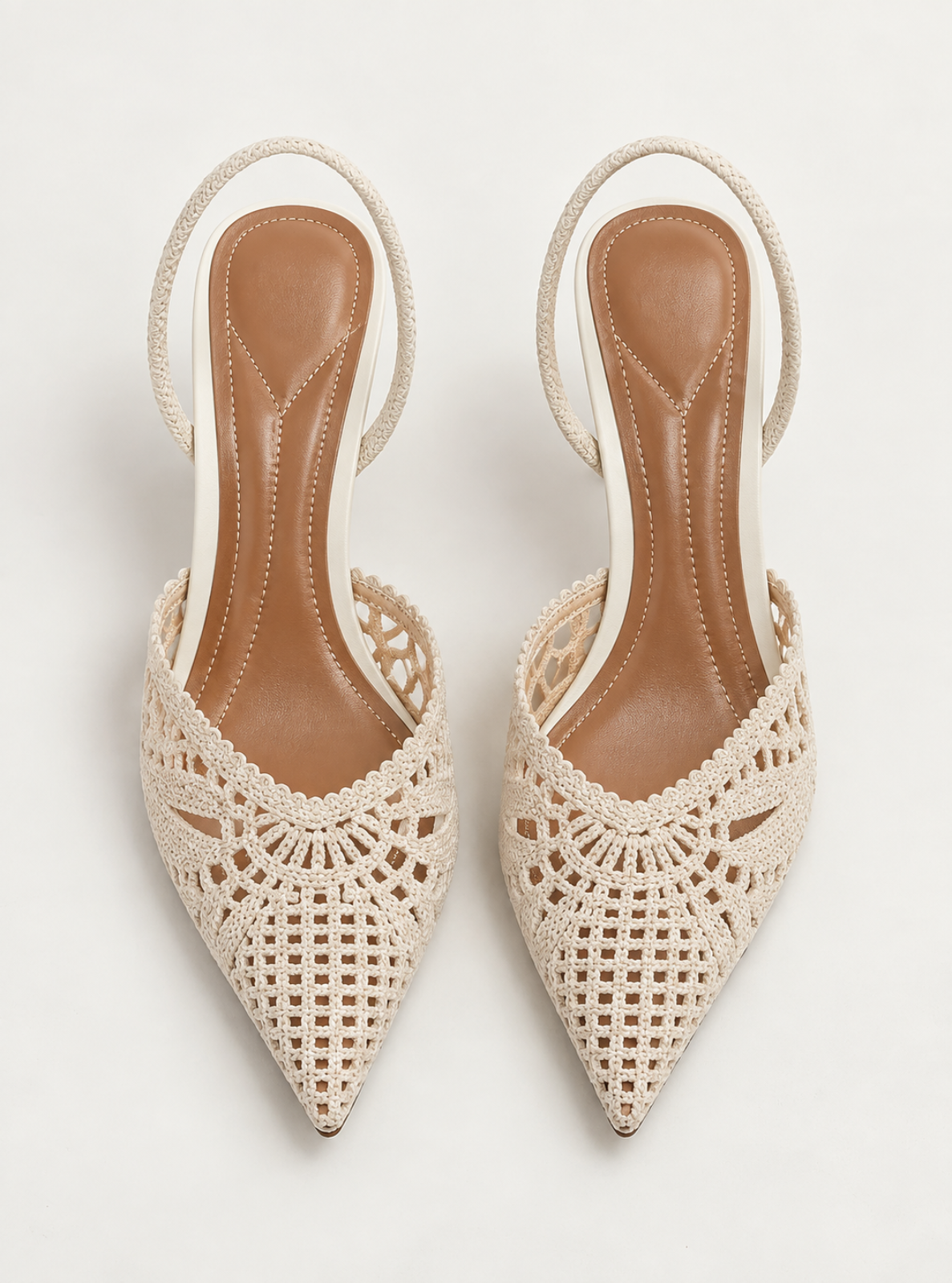 A pair of women's pointed-toe slingback heels with open crochet lace uppers and tan insoles, photographed from above on a light gray background.
