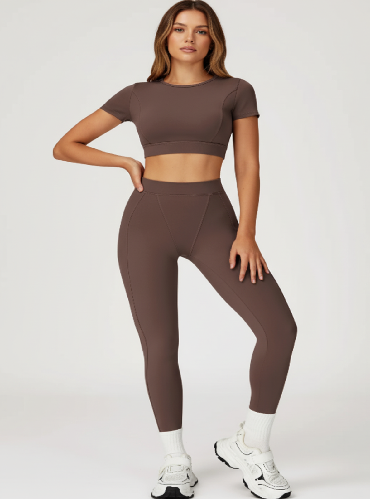 Woman wearing a brown athletic outfit on a white background
