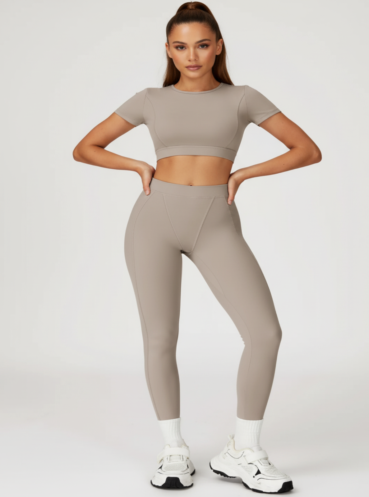 Woman wearing a beige athletic outfit on a white background