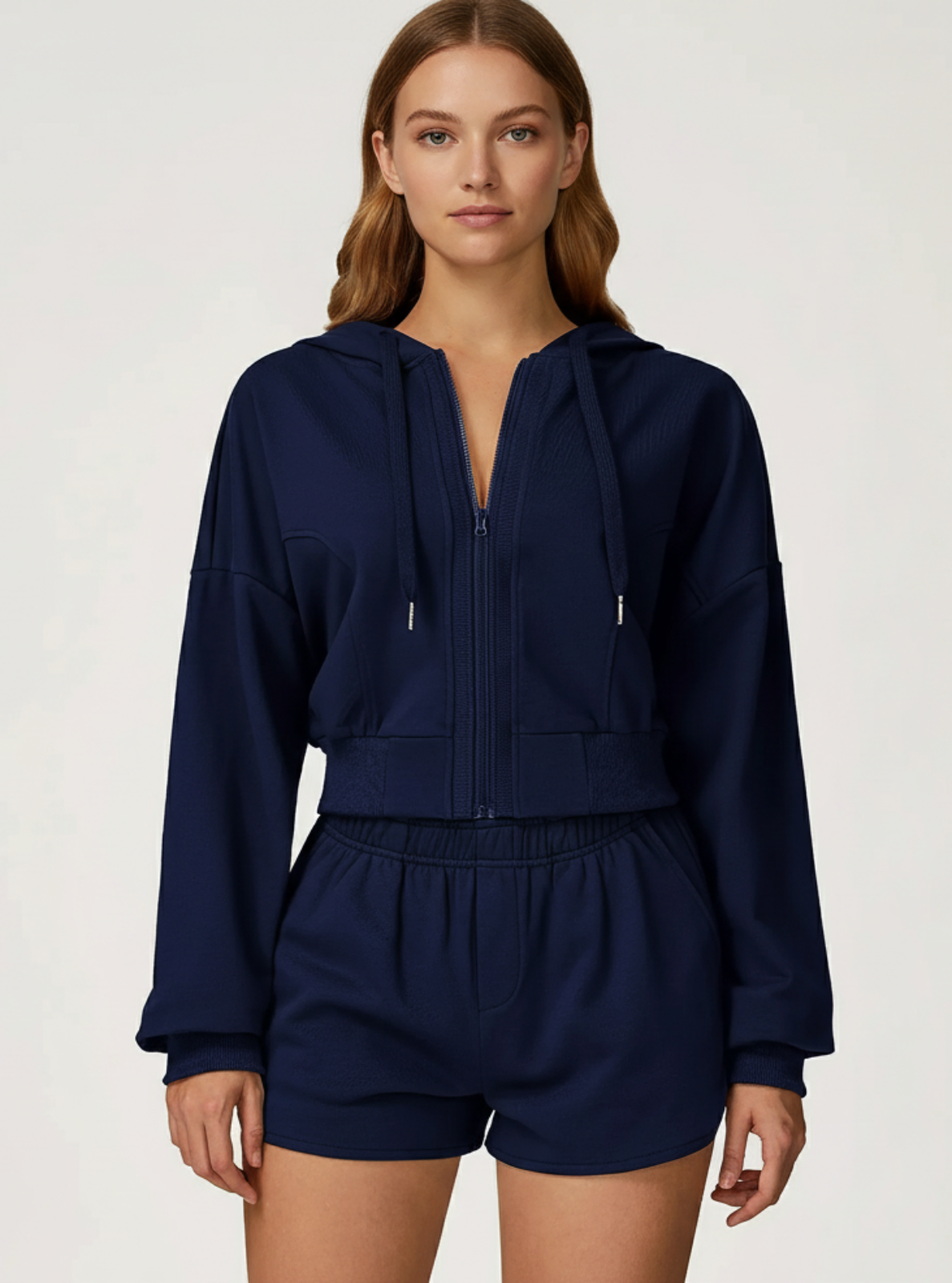 Woman wearing a navy blue tracksuit on a white background