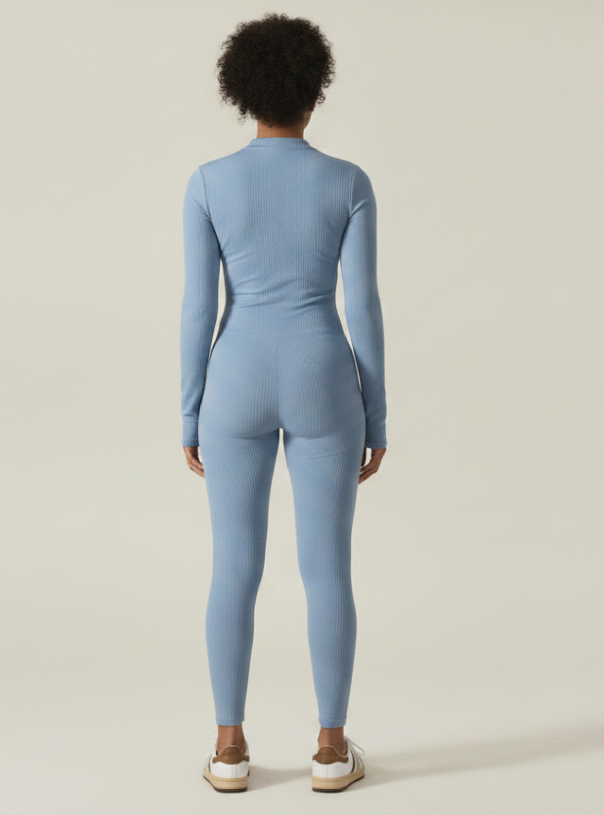Person wearing a blue jumpsuit on a plain background