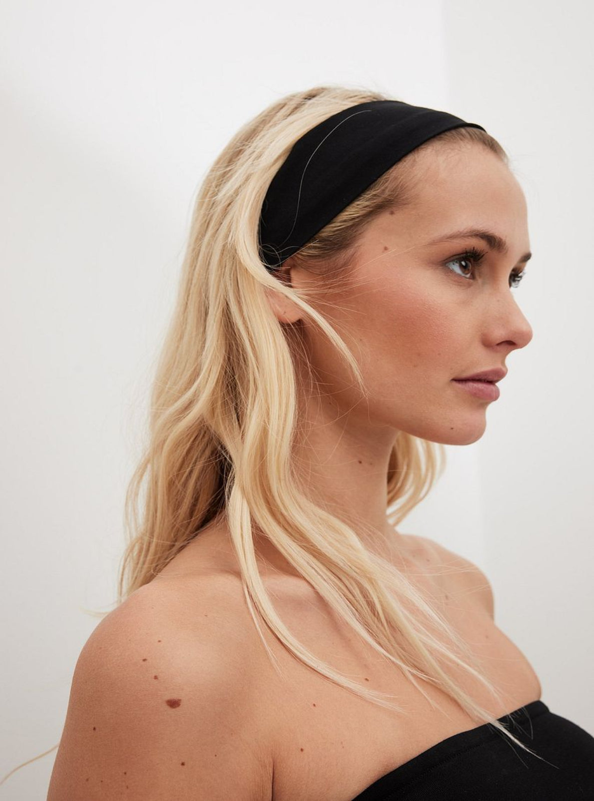 Woman wearing a black headband against a white background
