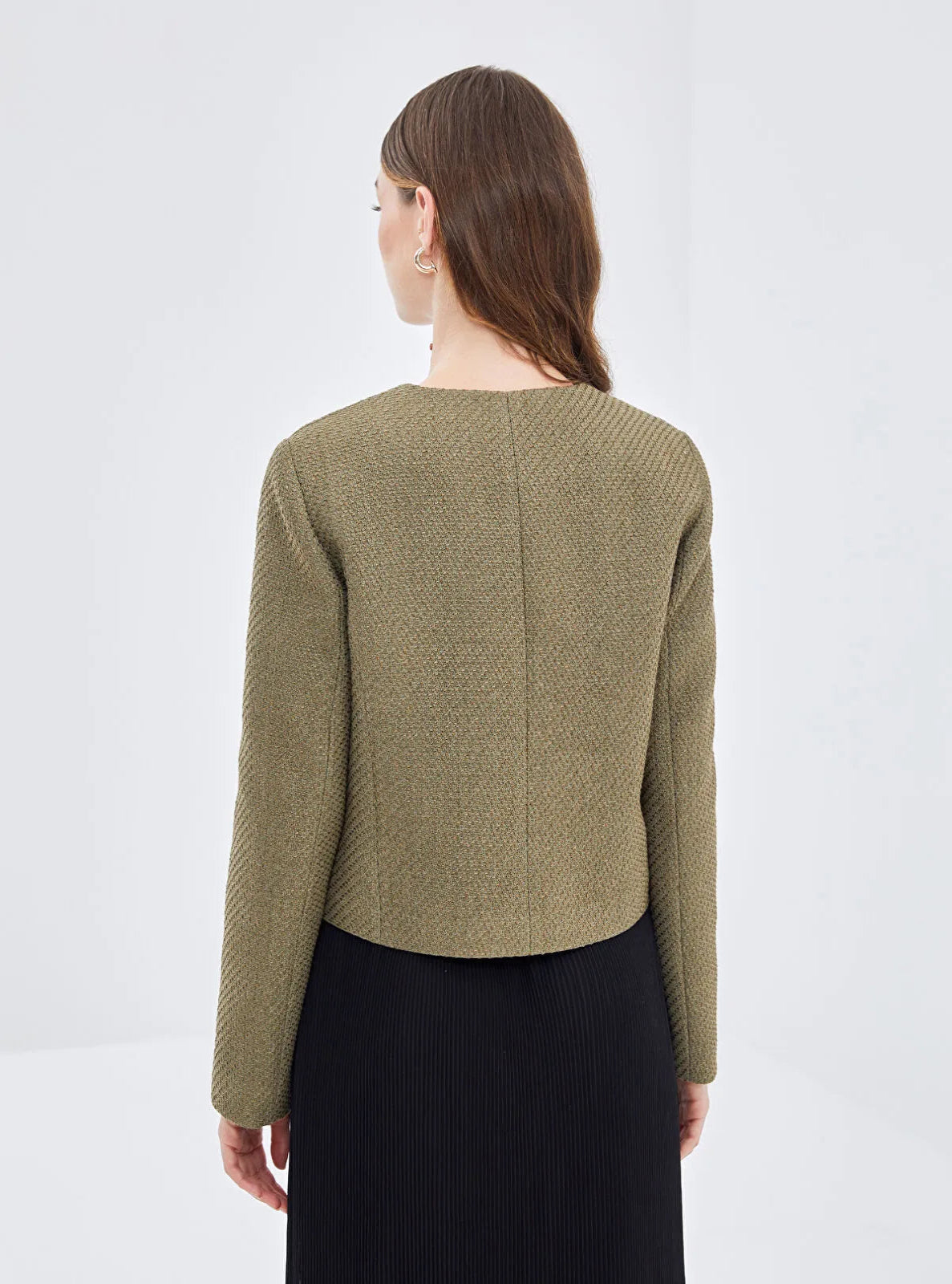 Model facing the white background wearing a khaki textured Jacket 